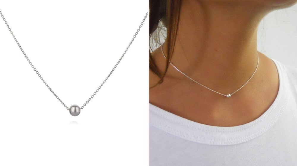 delicate silver chain choker with small silver ball on model's neck 