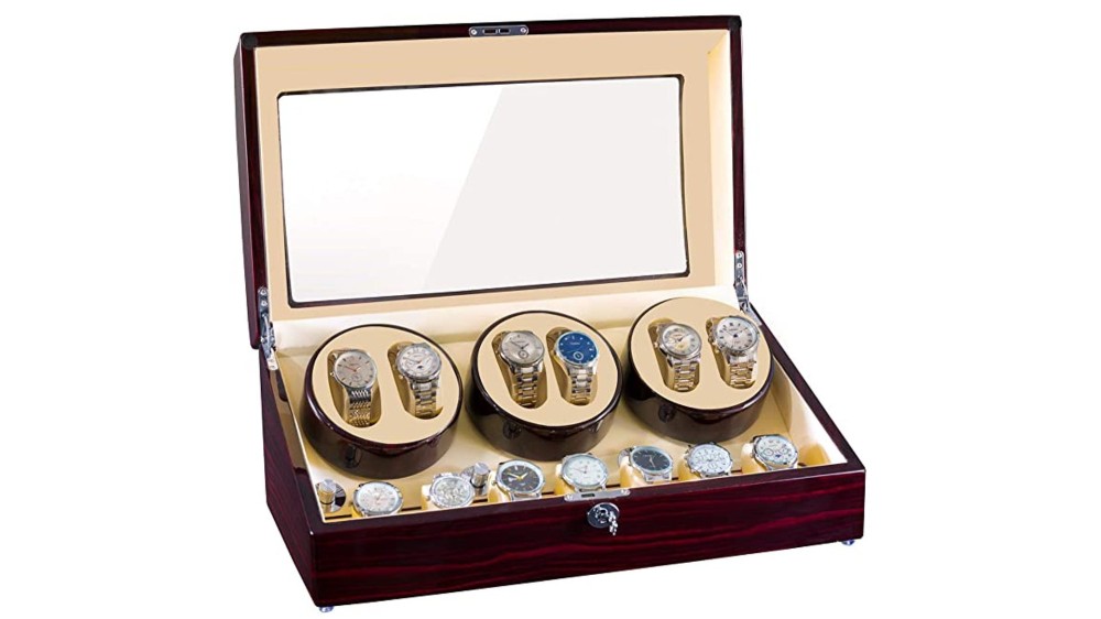 An opened wooden watch winder box that holds multiple watches inside.