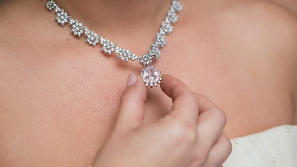 An intricate diamond necklace on a woman's neck.