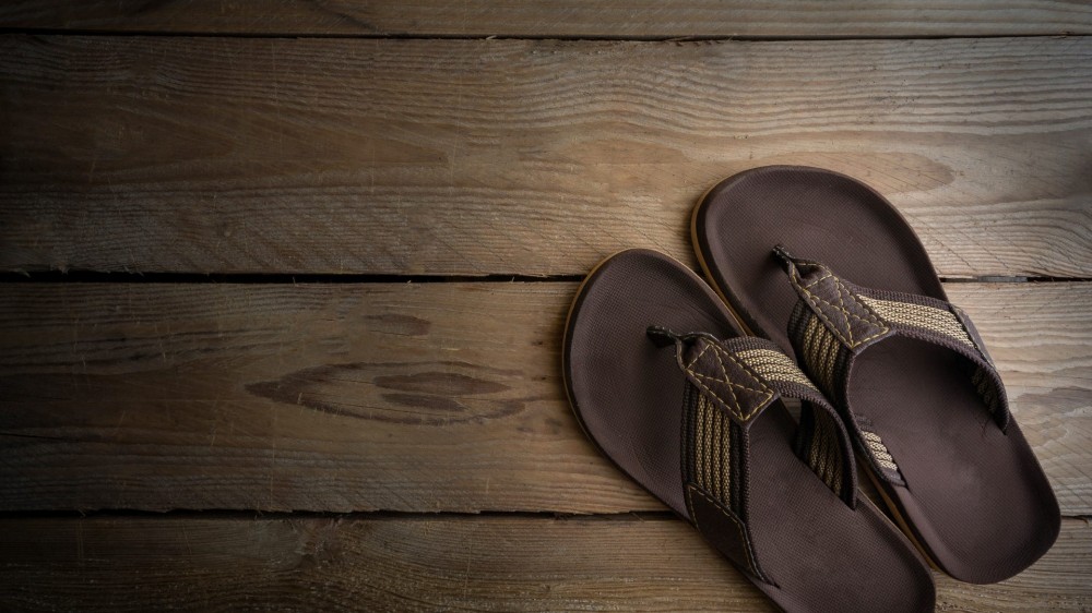 Men's sandals on wood floor.