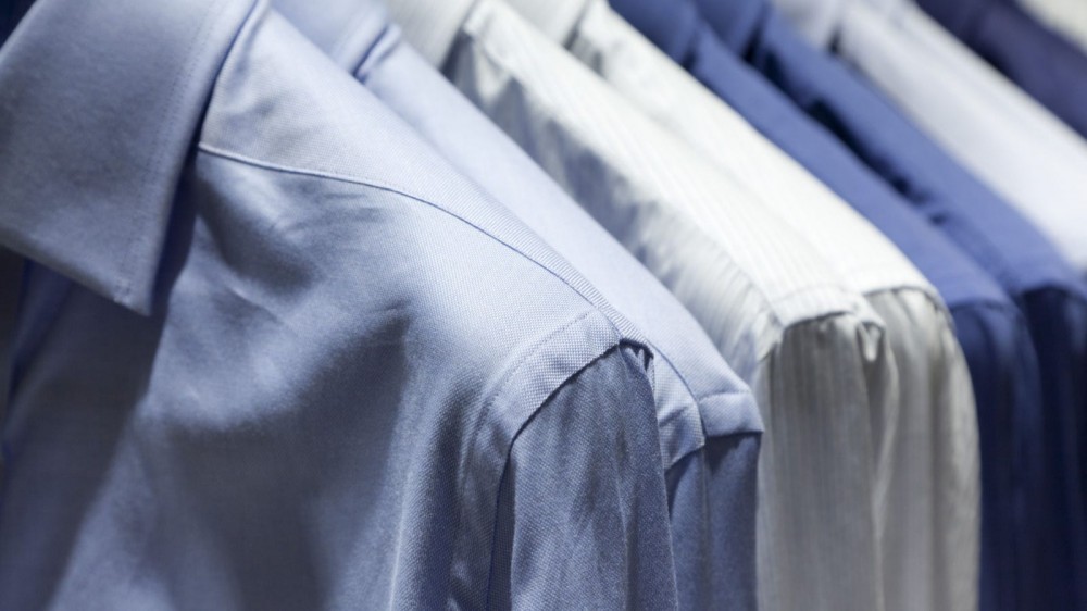 Close-up of men's blue dress shirts hanging