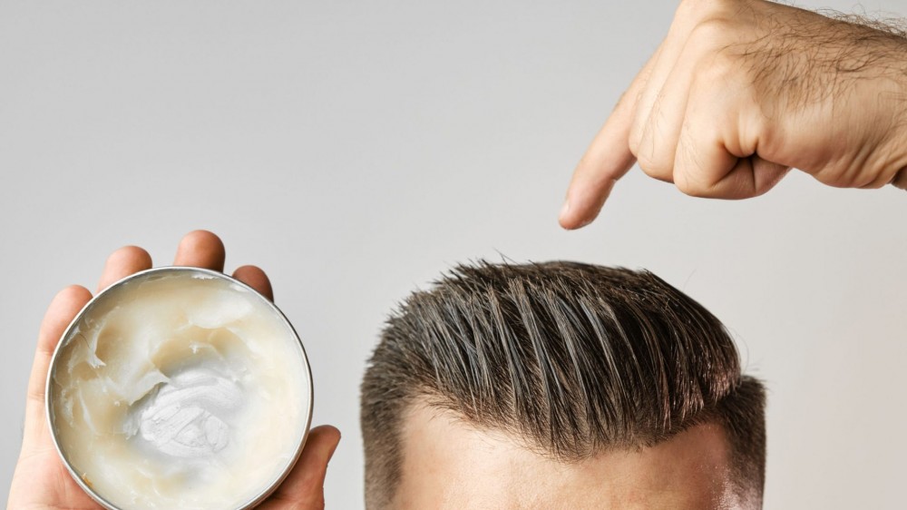 Man pointing to hair with hair gel.