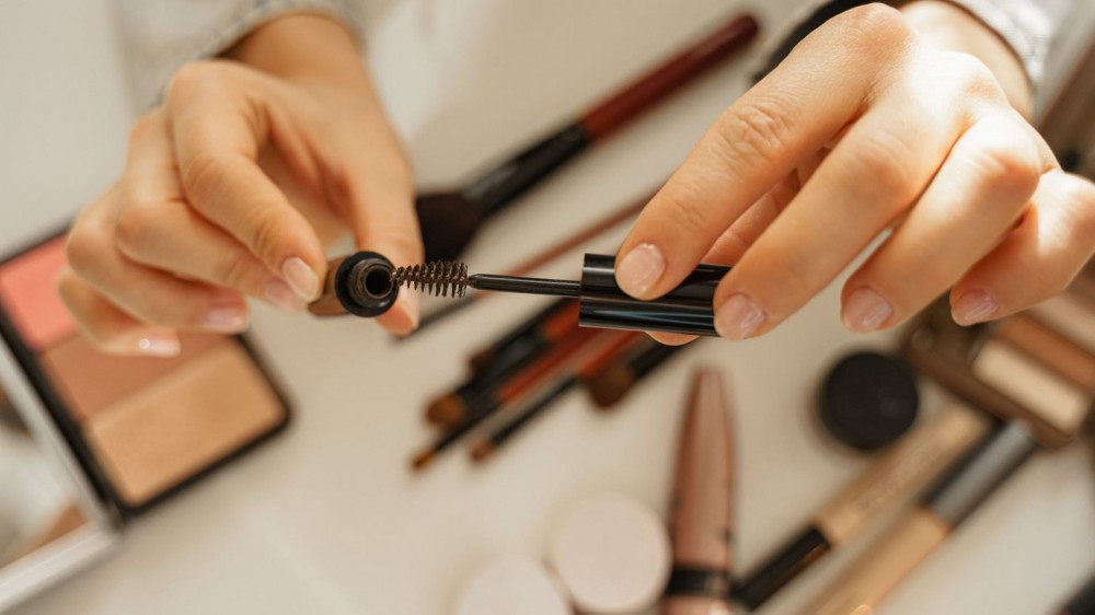 Woman holding eyebrow gel.