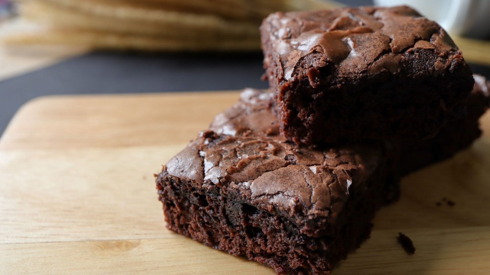 Thick and fudgy chocolate brownies on a cutting board