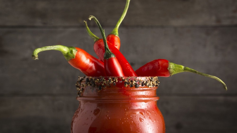 Bloody mary cocktail in a mason jar with chili peppers